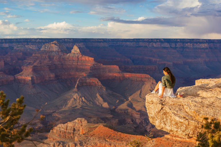 Young,Woman,On,A,Steep,Cliff,Taking,In,The,Amazing